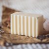 Crown Chakra Soap, unwrapped on crumpled brown paper with blurred rose buds, lavender petals and rose quartz | Shine Body & Bath