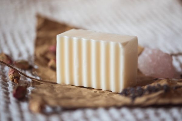 Crown Chakra Soap, unwrapped on crumpled brown paper with blurred rose buds, lavender petals and rose quartz | Shine Body & Bath