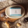 Throat Chakra Soap, wrapped on stone soap dish with smoking blurred incense cone and crystals - overhead | Shine Body & Bath