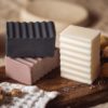 Group of three higher Chakra soaps | Crown Chakra Soap, Third Eye Chakra Soap, Throat Chakra Soap on wooden board with scattered lavender petals, flower buds, and crystals | Shine Body & Bath