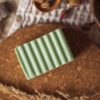 Heart Chakra Soap, unwrapped on cork board and cream waffle fabric with dried ear of grass and bowl of rose buds | Shine Body & Bath