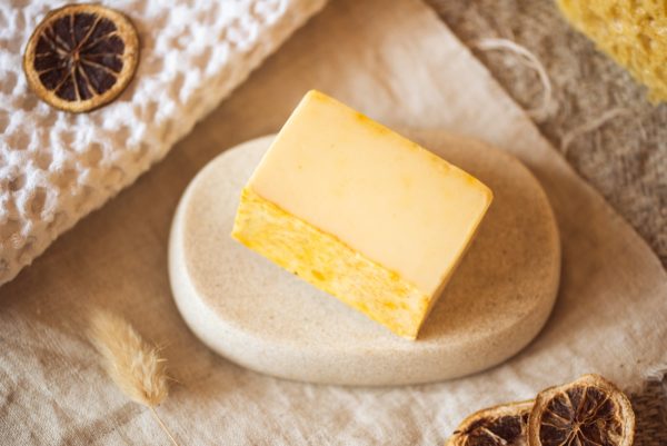 Solar Plexus Chakra Soap, unwrapped on stone soap dish and cream linen with scattered dried lemon slices | Shine Body & Bath