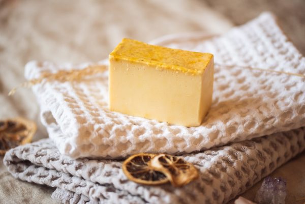 olar Plexus Chakra Soap, unwrapped on cream waffle fabric with two dried lemon slices and crystals | Shine Body & Bath