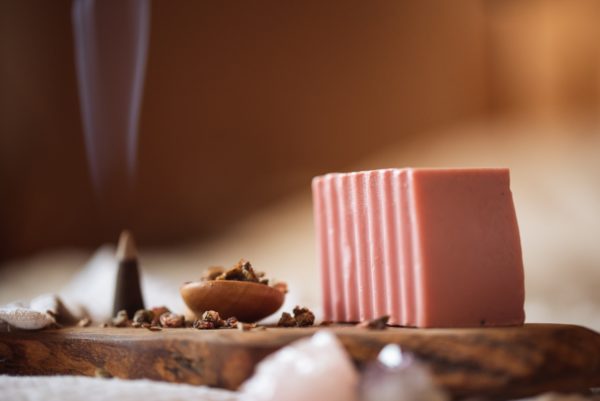 Root Chakra Soap, unwrapped on wooden board with smoking incense cone, scattered dried petals | Shine Body & Bath