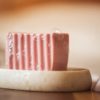 Root Chakra Soap, with bubbles sitting on a stone soap dish with crystals | Shine Body & Bath