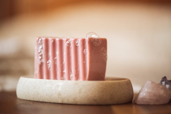 Root Chakra Soap, with bubbles sitting on a stone soap dish with crystals | Shine Body & Bath