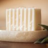 Crown Chakra Soap, with bubbles sitting on a stone soap dish with green herb leaves | Shine Body & Bath