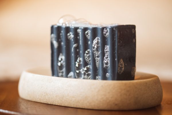 Throat Chakra Soap, with bubbles sitting on a stone soap dish | Shine Body & Bath