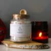 Root Chakra Ritual Bath Salts for Grounding & Strength | Glass jar of bath salts with amber candle | Shine Body & Bath