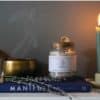 Throat Chakra Ritual Bath Salts for Communication & Truth | Glass jar of bath salts on blue book with lavender stems | Shine Body & Bath