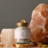Crown Chakra Ritual Bath Salts for Spirit & Inspiration | Glass jar of bath salts on shelf with large salt lamp and candle holder | Shine Body & Bath
