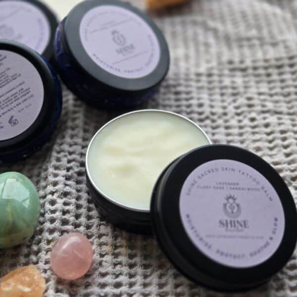 Shine Sacred Skin Tattoo Balm | Flat lay of tins of balm with crystals