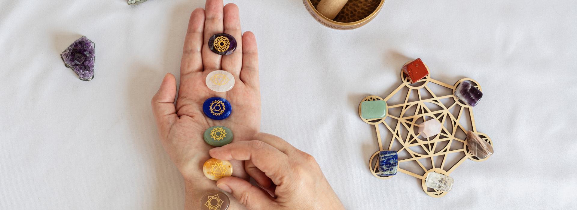 Essential Oils for Chakra Healing: Simple Scents to Balance Your Energy Blog | Woman's hand with chakra stones in palm
