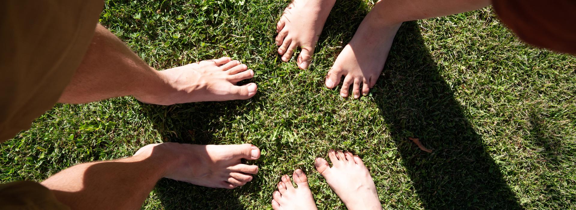 Essential Oils for Chakra Healing: Simple Scents to Balance Your Energy Blog | 3 pairs of bare women's feet on grass