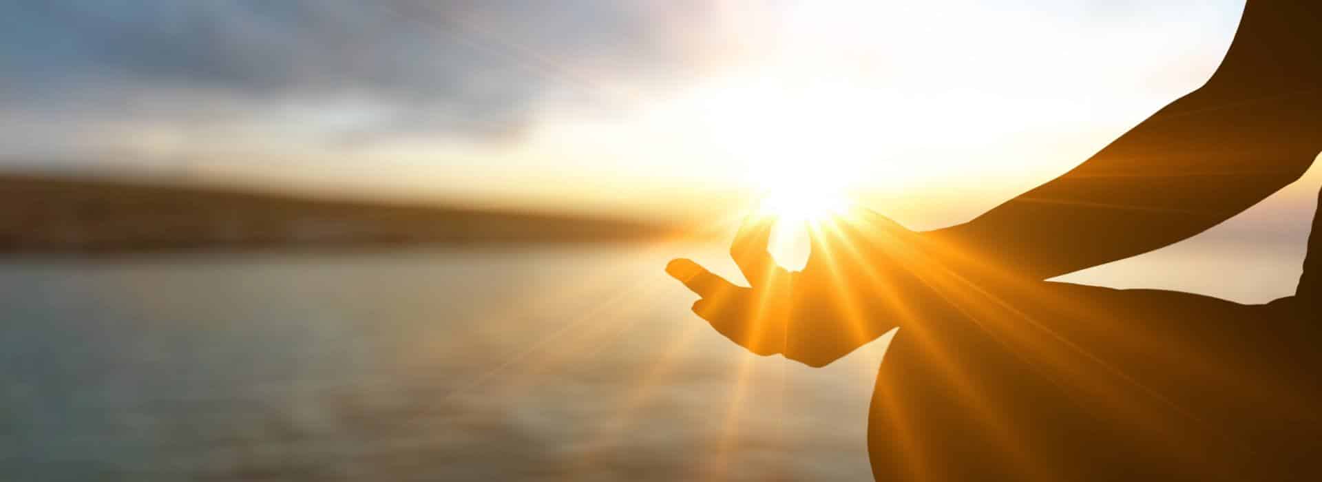 The Chakra System for Beginners - Your Complete Guide | Woman meditating at sunrise