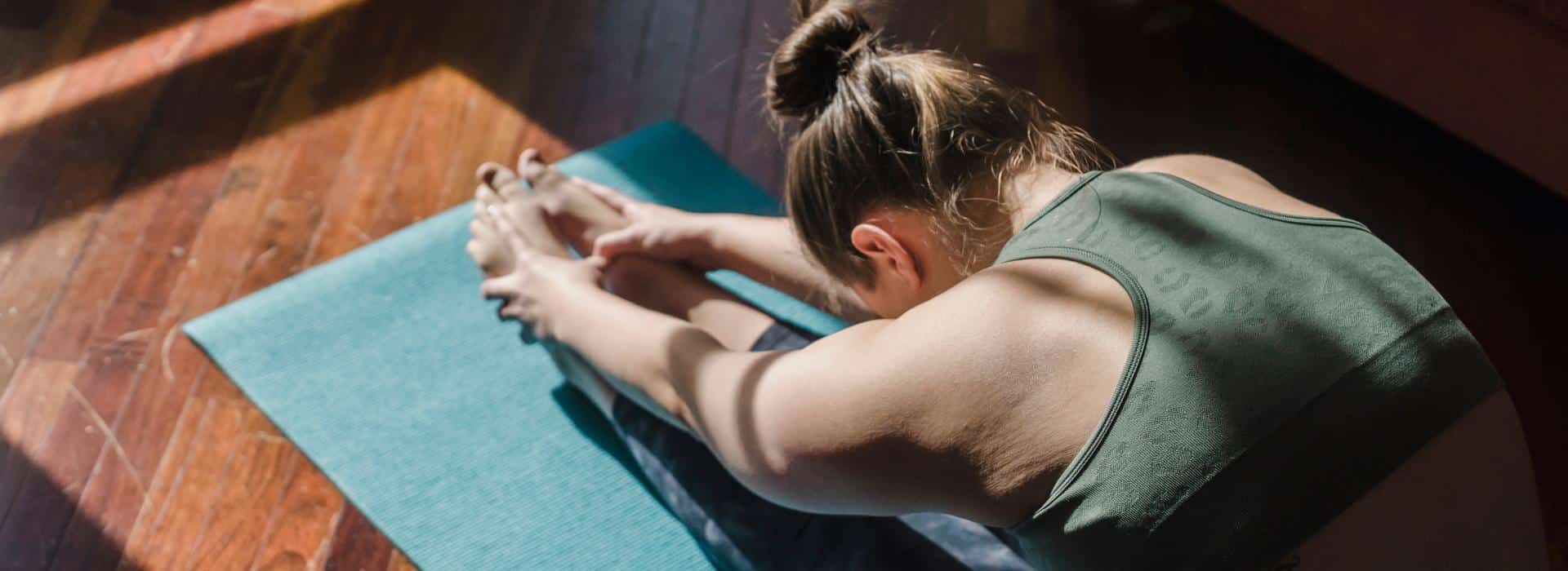 Essential Oils for Chakra Healing: Simple Scents to Balance Your Energy Blog | Woman stretching on a yoga mat