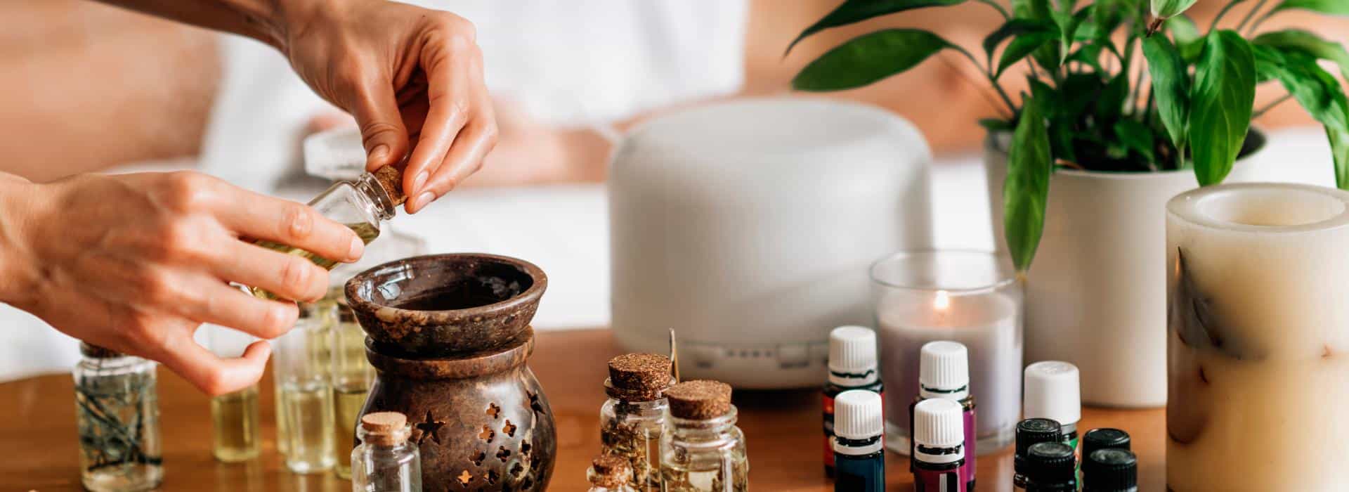 Essential Oils for Chakra Healing: Simple Scents to Balance Your Energy Blog | Woman dropping essential oils into a burner