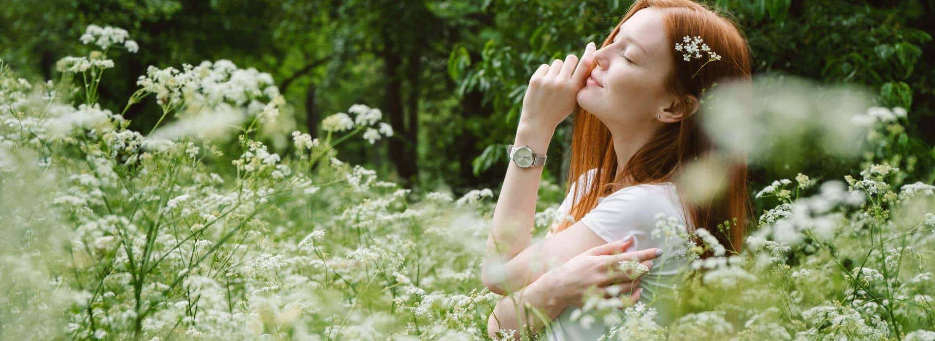 Manifesting vs Liberating Energy | Blissful woman in field surrounded by white flowers